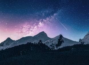Night sky with the Milky Way over snow-covered mountains