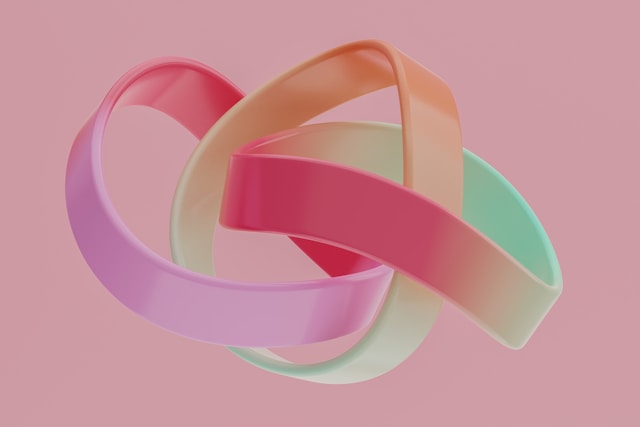 An abstract composition of colorful shapes against a pink background