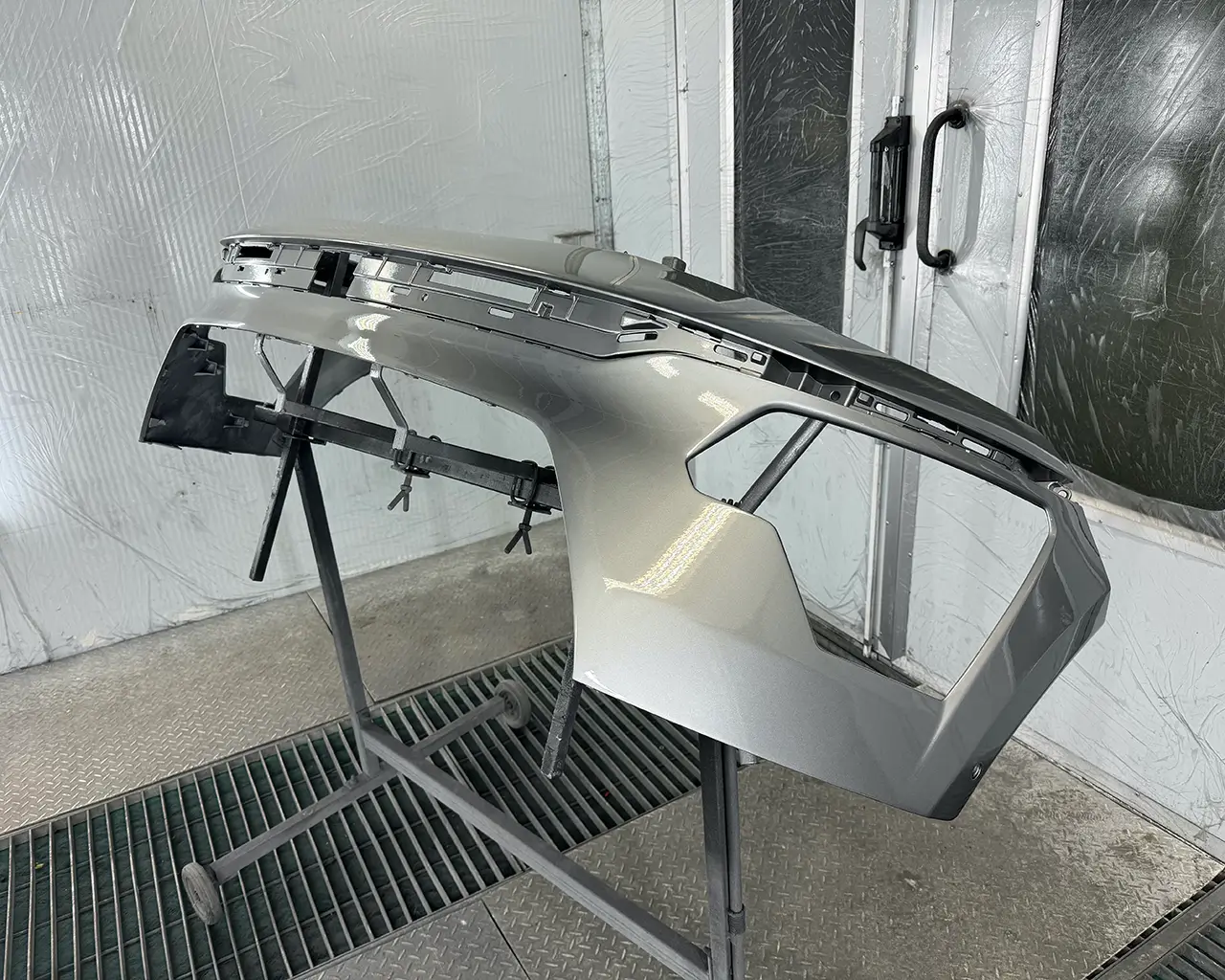 Передній бампер автомобіля після фарбування в камері. Видно свіжо нанесений шар фарби.