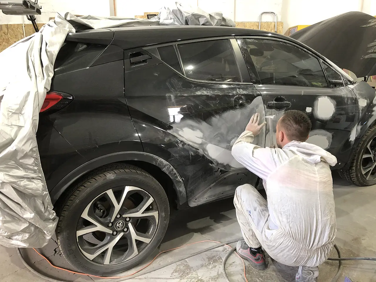 Майстер виконує малярні роботи Toyota C-HR для подальшої підготовки для фарбування